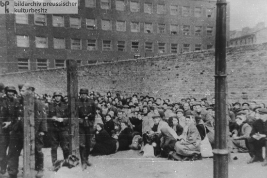 Niederschlagung des Warschauer Ghettoaufstandes: An der Ghettomauer zusammengetriebene Juden warten auf ihren Abtransport (Mai 1943) 